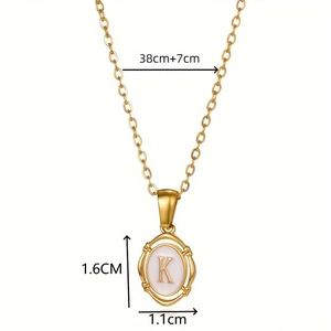 Gold oval letter K pendant necklace with white enamel inlay and adjustable chain