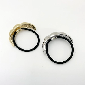 Detailed view of twisted U-shape gold and silver metallic hair ties with black elastic