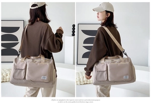 Detail of beige duffel bag featuring wet dry separation compartment and durable straps