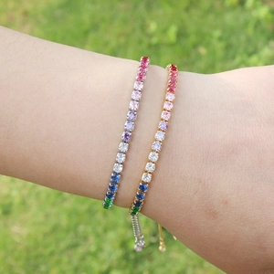 Rainbow tennis bracelets with colorful stones on gold and silver bands worn on wrist