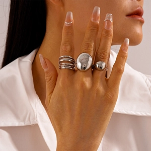 Close-up of three-piece silver geometric ring set including oval and beaded designs