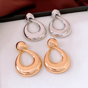Close-up of polished gold and silver waterdrop earrings on jewelry box padding