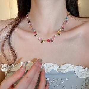 Close-up of a colorful geometric zircon necklace on a model's neck for a luxury look