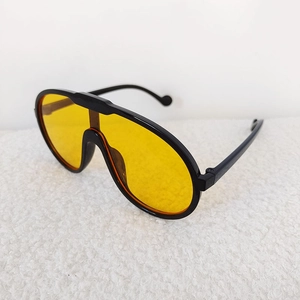 Detail view of sports kids sunglasses with black frame and yellow wrap-around lens