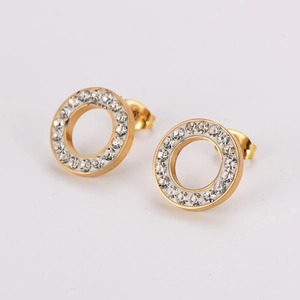 Gros plan de boucles d'oreilles dorées en acier inoxydable avec strass blancs sur fond blanc