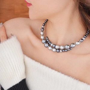 Détail d'un collier ras du cou en perles multicouches avec anneaux diamantés sur mannequin