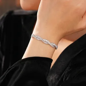 Elegant silver twisted bracelet with baguette-cut zircon stones worn by a model