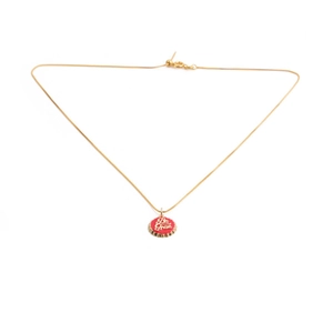 Detail of 18K gold plated necklace featuring a red bottle cap pendant with Be Free text