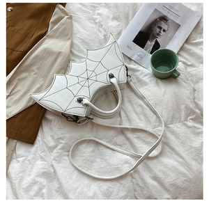 Detailed view of bat wing shaped PU handbag with spider web stitching and cross hardware