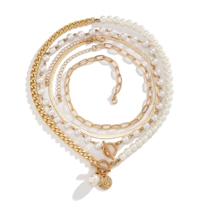 Close-up of gold layered chain necklace set with baroque pearls and textured pendant