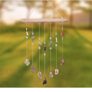 Detailed close-up of natural crystal stones and agate pendants on a wood stick wind chime