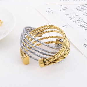 Detail of multi-layer C-shape steel cable cuff bracelet with gold and silver twisted wire