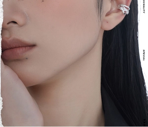 Close-up of S925 silver ear bone clip with irregular texture and black gemstones on model