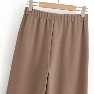 Detail of high-waist brown wide-leg pants with elastic waistband and crepe texture