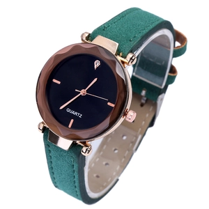 Detail of rose gold faceted bezel and dark green matte leather strap on quartz watch