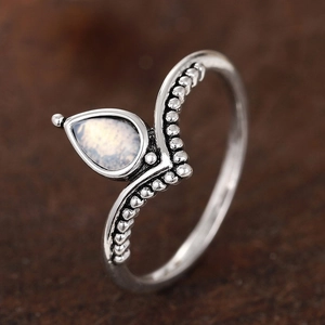Anello a V minimalista in argento con pietra di luna su sfondo di legno scuro