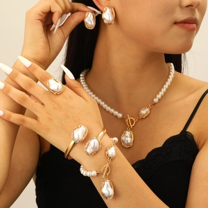 Detailed close-up of Baroque pearl necklace and earrings set worn by a model