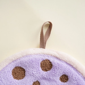 Detail of purple coral fleece hand towel with brown polka dots and hanging strap loop