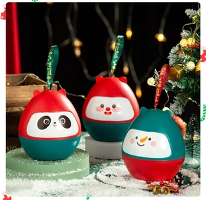 Three festive Christmas tumbler gift boxes with snowman and panda designs on faux snow