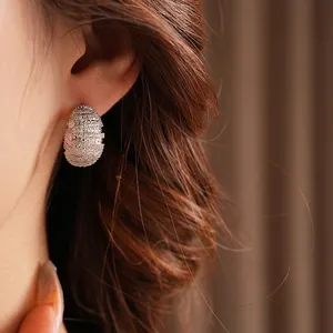 Silver-tone spiral textured stud earrings with pavé cubic zirconia on model
