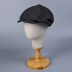Detailed close-up of retro black newsboy cap featuring classic eight-panel crown design