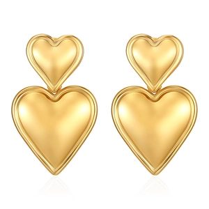 Detailed close-up of tiered golden heart earrings with a polished metallic finish