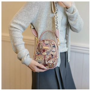 Detailed view of pink embroidered teddy bear handbag with adjustable crossbody strap