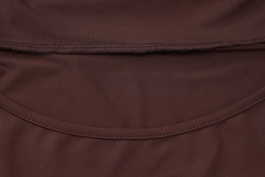 Macro shot of high-density dark brown knit fabric with premium stitching and texture