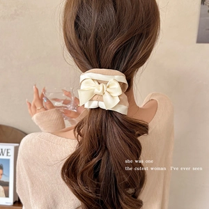 Elegant cream bow hair scrunchie in French vintage style on a model's ponytail