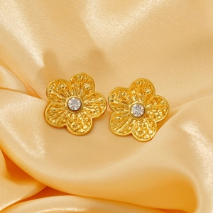Elegant gold flower pearl earrings with crystals on champagne silk background