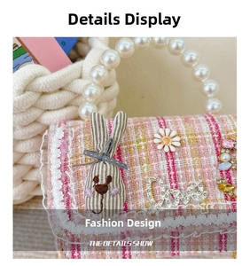 Detail of pink tweed girl's bag with pearl handle, ribbon bunny, and Love charm