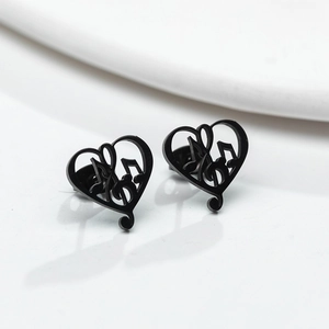 Detail of minimalist black heart musical note stud earrings on a clean white backdrop
