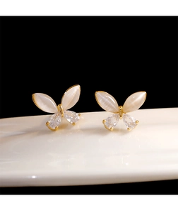 Macro shot of butterfly earrings with opal wings and sparkling zircon in gold plating