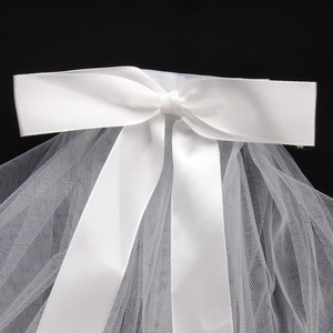 Detail of white bridal veil featuring a premium satin bow and delicate mesh texture