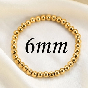 Detail shot of 6mm polished gold stainless steel beads on an elastic bracelet