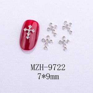 Dettaglio macro di ciondoli a croce 7x9mm per nail art con strass bianchi brillanti