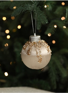 Detail of champagne Christmas ball with gold sequins and white beads on a tree