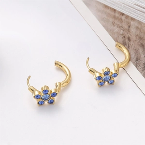 Detail of elegant five-petal blue crystal earrings with 18k gold plated floral setting