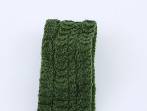 Detailed macro view of green knitted fabric texture and braided pattern on top strap