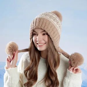 Fleece-lined Fair Isle knit hat with earflaps and fluffy pom-poms for winter warmth
