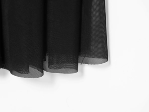 Close-up of elegant black mesh fabric with sheer texture and delicate pleated details