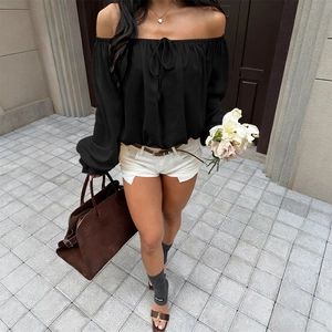 Women's black off-shoulder long sleeve top with lantern sleeves and front tie bow detail