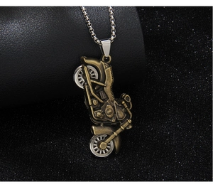 Close-up of vintage bronze motorcycle pendant on silver metal chain over dark texture