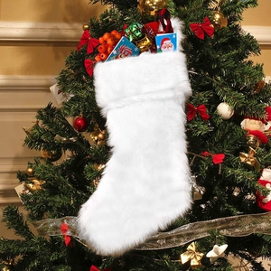 White faux fur Christmas stocking ornament hanging on a festive decorated holiday tree