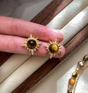 Détail de boucles d'oreilles étoile plaquées or 18 carats avec œil de tigre