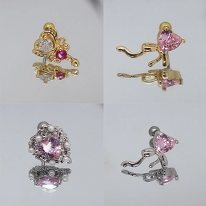 Dettaglio di orecchini a lobo con cuore rosa, fiocco dorato e accenti di perle