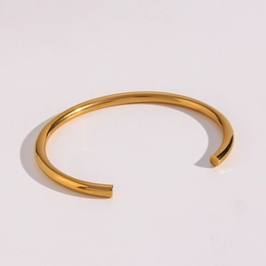 Detail of 18K gold plated minimalist open bangle showing smooth polished cylindrical metal