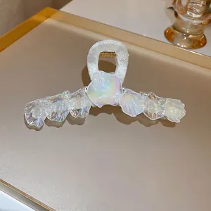 Pince à cheveux coquillage aux reflets irisés et ressort doré au fini perlé