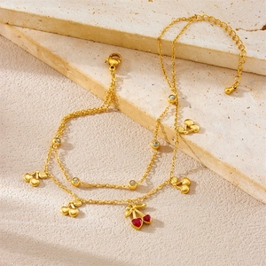 Gold double-layer anklet with red cherry pendant and sparkling crystal accents