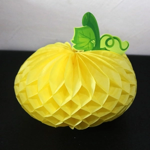 Detail of yellow honeycomb paper pumpkin with green leaf for Thanksgiving party decoration